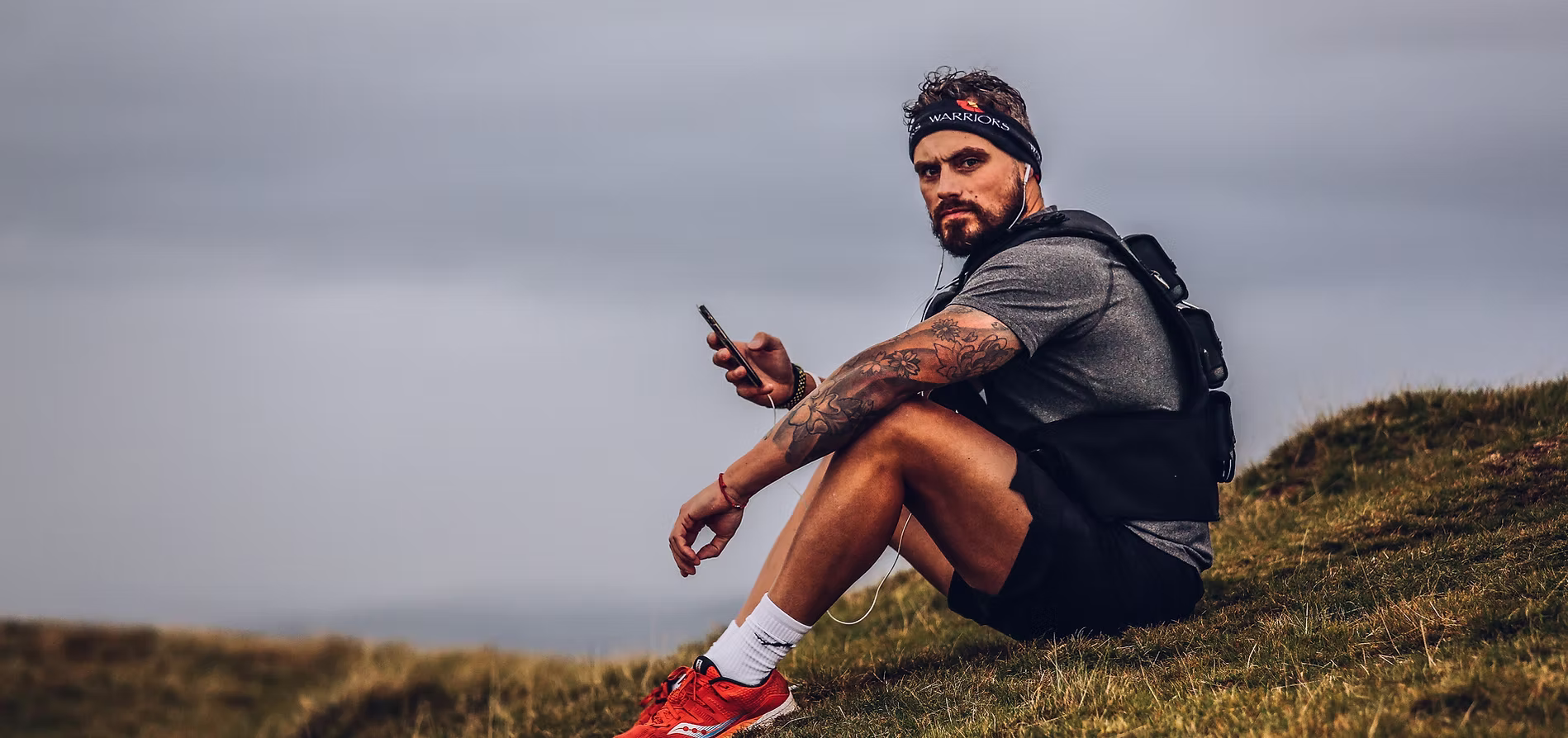 Josh Llewellyn-Jones sitting on a hillside during an endurance challenge
